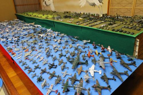 a large display of toy planes on a blue table at Morizuya in Toyooka