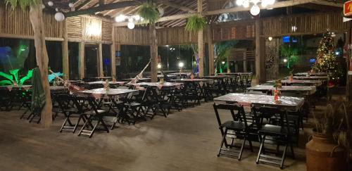 un groupe de tables et de chaises dans un restaurant dans l'établissement Residencial dos Portugas, à Boraceia