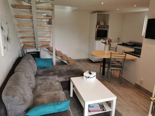 a living room with a couch and a table and a kitchen at Gite d' angel in Kermaria-Sulard