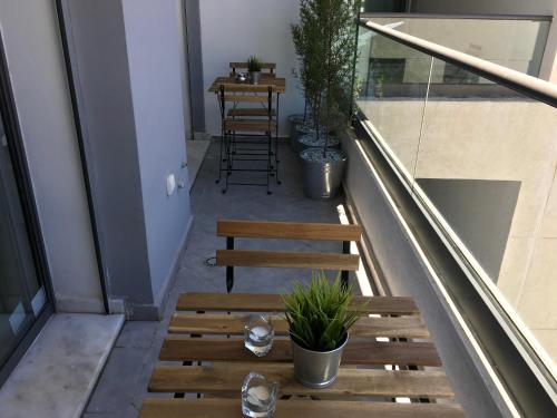 Un balcón con 3 bancos de madera y una mesa. en Appartement les pieds dans l'eau WELCOME STAY, en Mohammedia