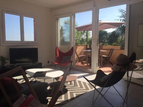 a living room with chairs and a table and an umbrella at Saberic in Vence