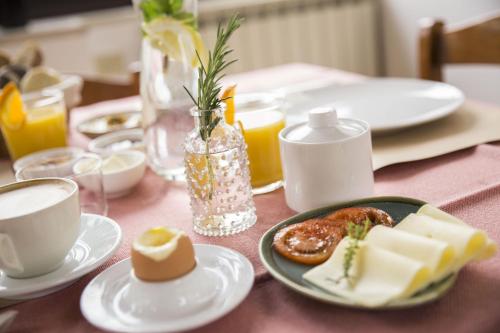 a table with plates of food and cups of coffee at Albergo Mio Boutique Hotel - Adults Only in Lazise