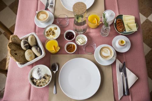 a table with plates of food on a pink table at Albergo Mio Boutique Hotel - Adults Only in Lazise