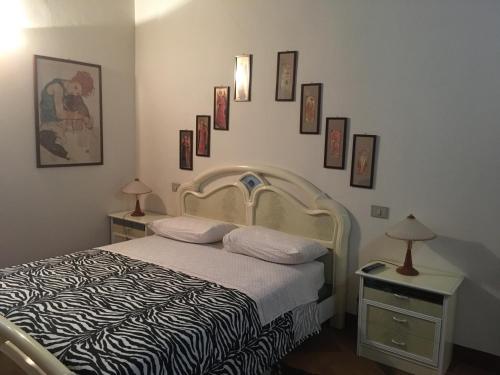 Schlafzimmer mit einem Bett und gerahmten Bildern an der Wand in der Unterkunft Al Borgo in Sansepolcro