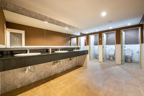 ein Badezimmer mit 2 Waschbecken und 2 WCs in der Unterkunft Scala Hostel in Bangkok