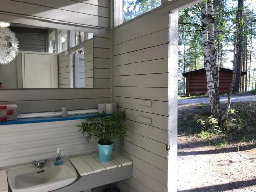a bathroom with a sink and a mirror at Koskenselkä Camping in Puumala