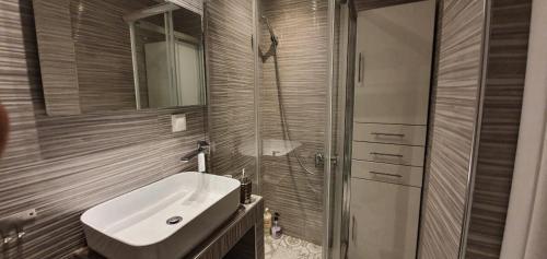 a bathroom with a white sink and a shower at Vivian House in Thessaloniki