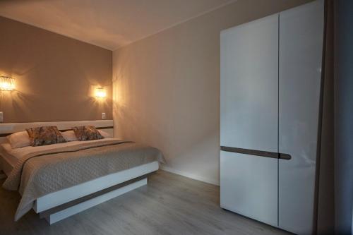 a bedroom with a bed and a white closet at Gardenia Sea Side MARTINA 2 Dziwnów in Dziwnów