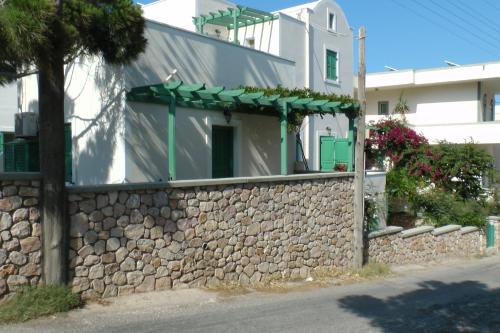 a building with a stone wall next to a building at Santa Magia in Kamari