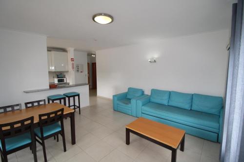 ポルティマンにあるApartamentoSolPraia - Areias da Rochaのリビングルーム(青いソファ、テーブル付)