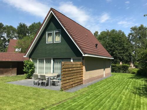 a green house with a table and chairs in a yard at Villa Oscar with sauna in Winterswijk in Winterswijk