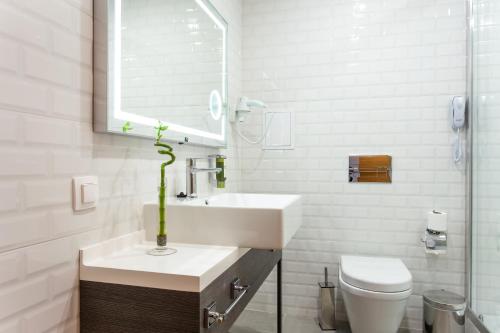 a white bathroom with a sink and a toilet at Best Western Terminus Hotel in Sofia