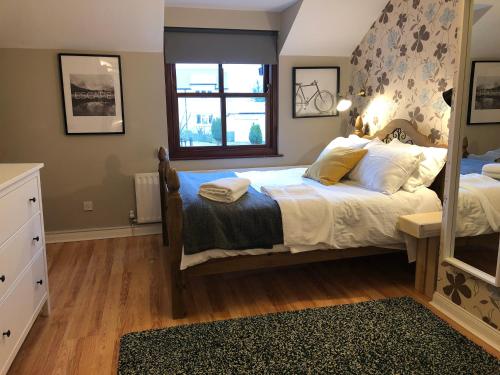 um quarto com uma cama grande e uma janela em Picturesque Village House em Aghnablaney