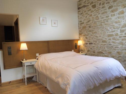 um quarto com uma cama e uma parede de pedra em The Coachhouse @ Kingsfort House em Ballintogher