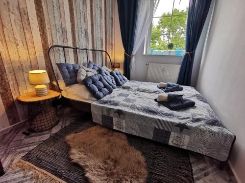 a bedroom with a bed and a window and a rug at Apartament Kołobrzeg Starówka Welcome Home in Kołobrzeg
