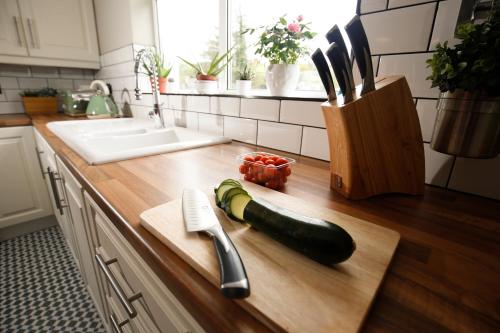 a kitchen counter with a zucchini on a cutting board at Picturesque Village House in Aghnablaney