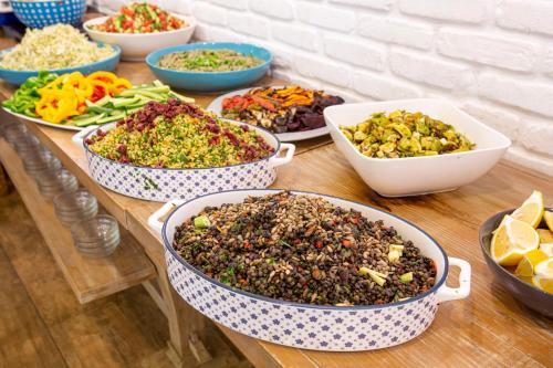a table topped with bowls of different types of food at Kibbutz Malkiya Travel Hotel in Malkiyya