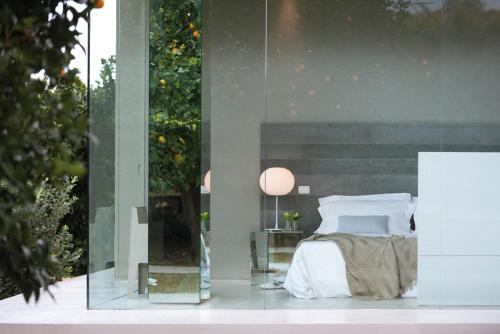 a bedroom with a bed and a glass wall at Zash Country Boutique hotel & SPA in Giarre