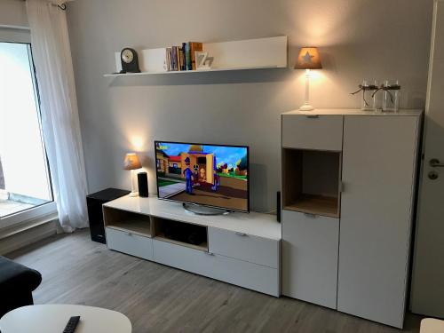a living room with a television on a white entertainment center at FeWo Julie in Winterberg