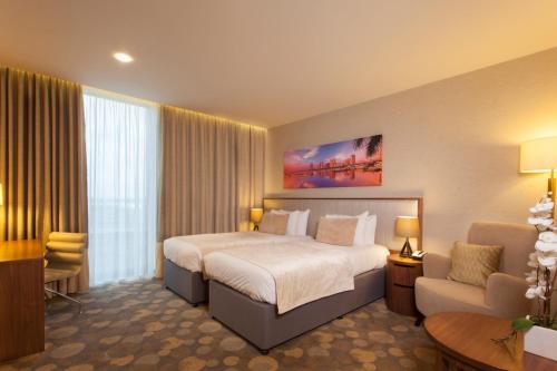 a hotel room with a large bed and a television at Genting Hotel at Resorts World Birmingham in Bickenhill
