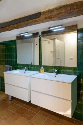 a bathroom with two sinks and a large mirror at Mas Nofre in Vilademuls