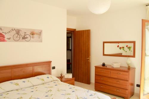 a bedroom with a bed and a dresser and a mirror at Casa dei Fiori in Roseto degli Abruzzi