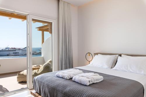 a bedroom with a bed with towels on it at Avra Mykonos in Tourlos