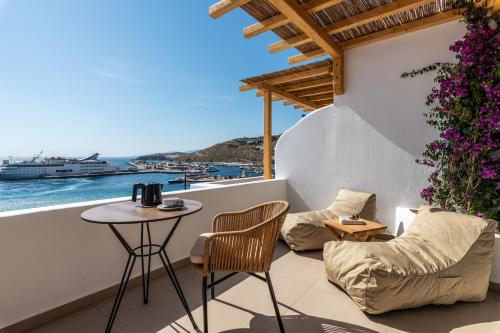 a balcony with a table and chairs and a view of the ocean at Avra Mykonos in Tourlos