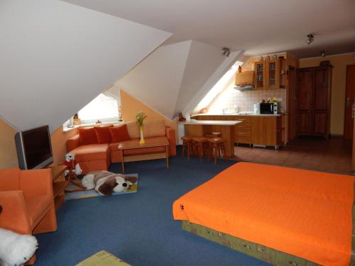 a living room with orange furniture and a dog laying on the floor at Apartmány v Terchovej in Terchová