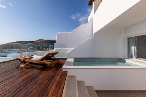 a house with a swimming pool and a deck at Avra Mykonos in Tourlos