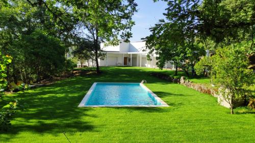 a swimming pool in the yard of a house at Casa de Apeleiras in Marco de Canaveses
