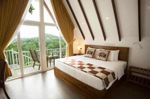 a bedroom with a bed and a large window at Orchid Villa Kandy in Kandy