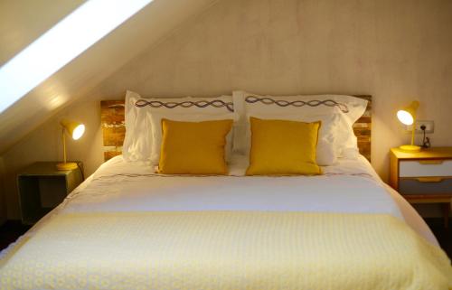 sypialnia z dużym łóżkiem z żółtymi poduszkami w obiekcie Jeans Apartment w mieście Horjul