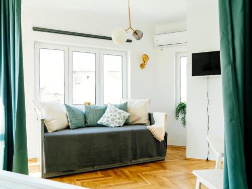 a living room with a couch with pillows at City retro studio in the middle of Old Town in Bucharest