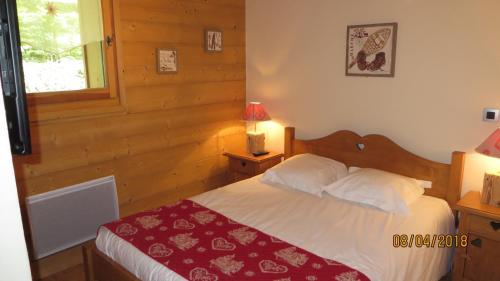 une chambre avec un lit avec une couverture rouge dans l'établissement Alpine Lodge 8, aux Contamines-Montjoie