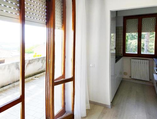 une porte ouverte menant à une chambre avec fenêtre dans l'établissement CONERO APARTMENT, à Castelfidardo