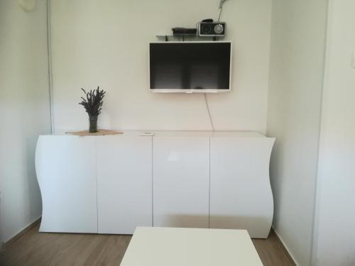 a room with white cabinets and a tv on a wall at Summer cottage with breathtaking view in Zečevo Rogozničko
