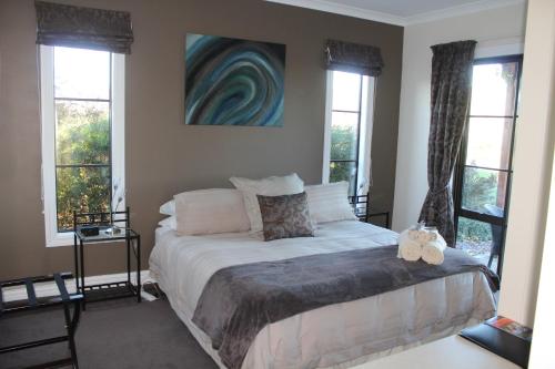 a bedroom with a bed and two windows at The Summit Lodge in Gladstone