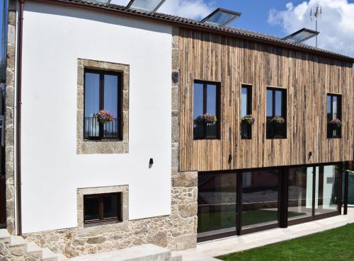 a house with a wooden facade and windows at LIRESCA in Lires