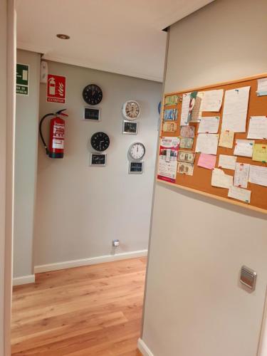 a room with a wall with clocks and papers at Pensión El Espolón in Logroño
