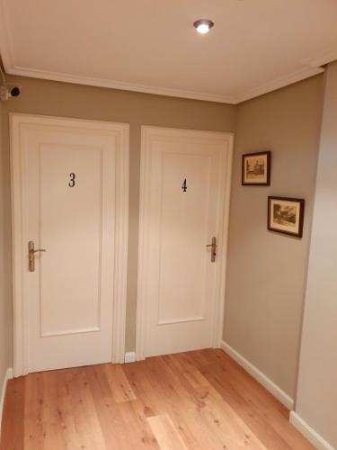 two doors with numbers on them in a room at Pensión El Espolón in Logroño