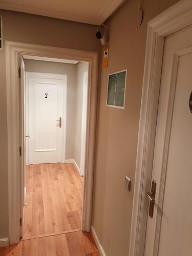 a hallway with a white door and a wooden floor at Pensión El Espolón in Logroño