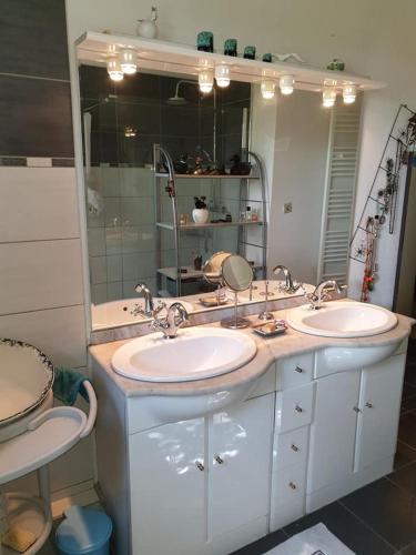 une salle de bain avec deux lavabos et un grand miroir dans l'établissement La Maison de Fafa, à Carcassonne