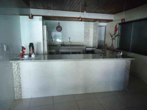 a kitchen with a large white counter top at Pousada Vida Boa in Cabo Frio