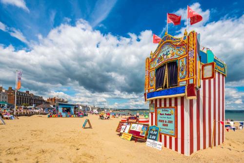 a lifeguard tower on a beach with people on it at Timrick Lodge in Weymouth