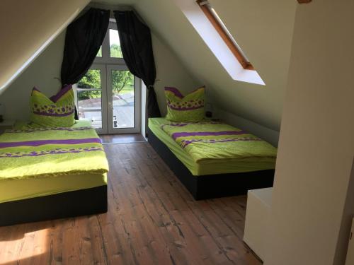 2 camas en un ático con ventana en FeWo Altwahnsdorf, en Radebeul