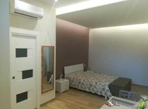 1 dormitorio con cama y espejo en Casa Melograno, en Bernalda