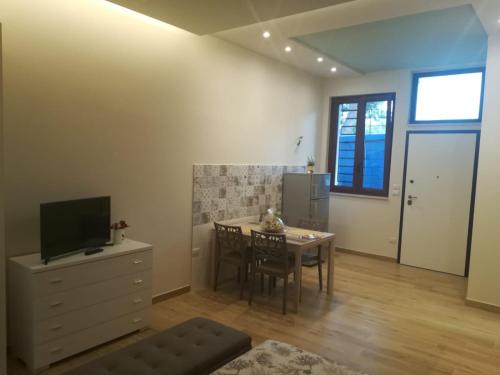 a living room with a table and a tv at Casa Melograno in Bernalda