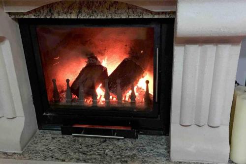 a fireplace with a fire in it at Guest House Stena in Ersekë