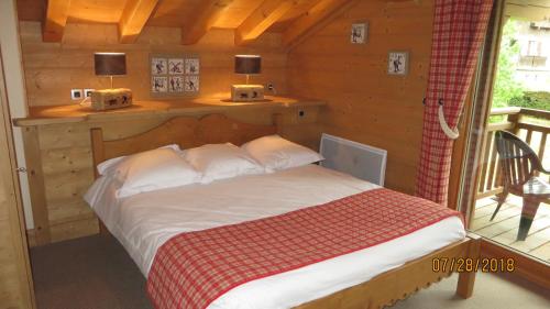 um quarto com uma cama num chalé de madeira em Alpine Lodge 7 em Les Contamines-Montjoie